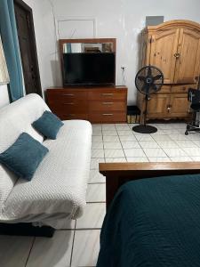 een slaapkamer met een bed en een tv op een dressoir bij COZY QUEEN BED STUDIO NEAR DOLPHIN MALL-FIU in Miami