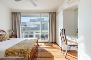 una camera da letto con un letto e una grande finestra di Beyond the Blue - Beachfront Beauty on Your Doorstep a Melbourne