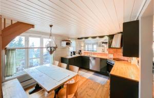 a kitchen with a table and a large window at Awesome Home In yer With House A Mountain View in Øyer