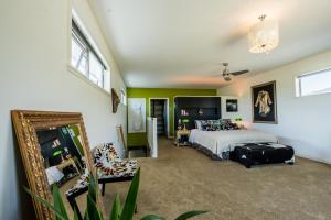 1 dormitorio con cama y espejo en The Artist's House Wanaka en Luggate