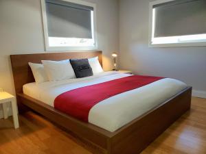 uma cama grande num quarto com 2 janelas em Cribs on the Hill em Picton