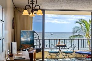 a room with a balcony with a view of the ocean at Sugar Beach Resort 531- Direct oceanfront gem at Sugar Beach Resort in Kihei