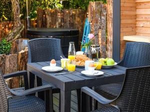 a wooden table with chairs and a plate of food at Orchard Cabin-rowan - Uk45435 in Isle of Whithorn