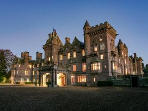 an old castle with lights on in front of it at Glen Apartment - Uk43813 in Ardovie