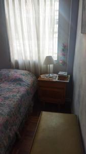 een slaapkamer met een bed en een bureau met een raam bij Hermoso y cómodo departamento en la zona sur cerca a San Miguel in La Paz