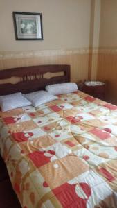 een bed met een kleurrijke quilt op in een slaapkamer bij Hermoso y cómodo departamento en la zona sur cerca a San Miguel in La Paz
