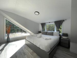 1 dormitorio con 1 cama grande y ventana grande en Le Petit Saphir en Rawdon