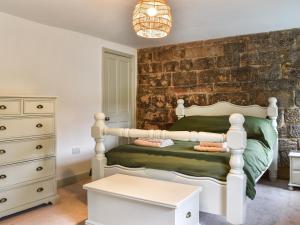 um quarto com uma cama e uma parede de tijolos em Kilaine Cottage em Loftus