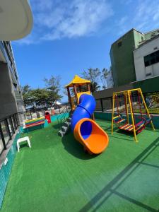 un parque infantil con toboganes coloridos y una estructura de juegos en Apartamento em frente à praia Barra da Tijuca, en Río de Janeiro