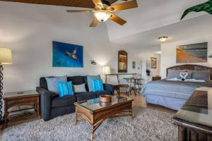 Kihei Bay Surf 208- Updated partial oceanview studio across from beach في كيهي: غرفة معيشة مع سرير وأريكة