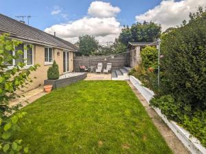 a backyard with a lawn and a house at Fell View House in Kendal