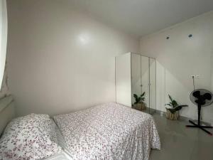 a white bedroom with a bed and a cabinet at Beautiful 3BR Home - 8 min from Centre by Sakura 