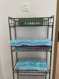 a black shelf with blue towels on it at Beautiful 3BR Home - 8 min from Centre by Sakura 