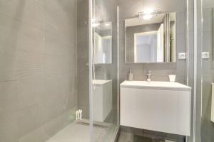 ein weißes Badezimmer mit einem Waschbecken und einem Spiegel in der Unterkunft Beautiful and cosy flat with terrace 1BR4p - Cannes in Cannes