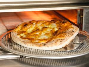 a pizza sitting on a rack in a toaster oven at Hotel Ichinose in Yamanouchi
