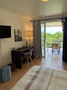a bedroom with a desk and a view of a patio at Studio Charme et cosy à Sainte-Luce Martinique in Sainte-Luce