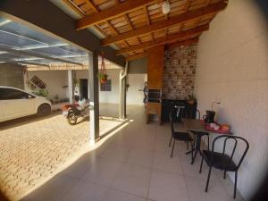 eine Terrasse mit einem Tisch und Stühlen sowie eine Garage für Autos in der Unterkunft Quarto Aconchego em Canaã dos Carajás in Canaã dos Carajás