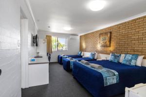 1 Schlafzimmer mit 2 Betten und Ziegelwand in der Unterkunft Leichhardt Motor Inn in Toowoomba