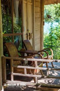 two chairs sitting on the porch of a house at La Maison De Buoc in Mai Chau