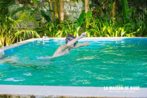 een jonge man in een zwembad in het water bij La Maison De Buoc in Mai Chau