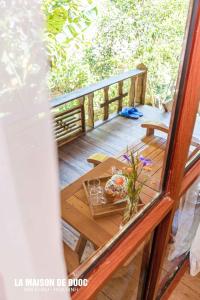 een houten terras met een tafel met bloemen erop bij La Maison De Buoc in Mai Chau