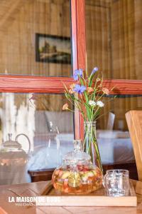 a glass vase with flowers in it on a table at La Maison De Buoc in Mai Chau