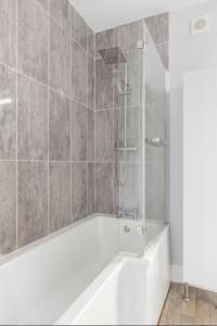 a bathroom with a shower with a white tub at Paradise House Darlington in Darlington