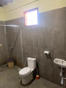 a bathroom with a toilet and a sink at Cemara Siu Bungalow in Sembalun Lawang