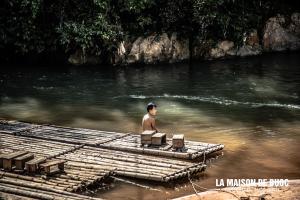 een man op een vlot in het water bij La Maison De Buoc in Mai Chau