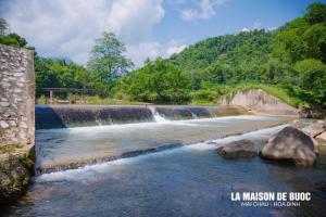 een waterval in het midden van een rivier bij La Maison De Buoc in Mai Chau