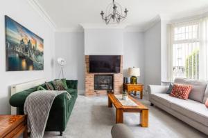 a living room with a green couch and a fireplace at Paradise House Darlington in Darlington