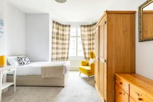 a bedroom with a bed and a yellow chair at Paradise House Darlington in Darlington