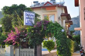 a sign on the side of a house with flowers at Dogan Apart Hotel in Göcek