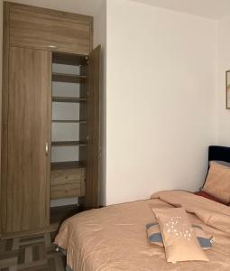 a bedroom with a bed and a wooden cabinet at SYN - Corniche in Brazzaville