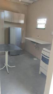 uma cozinha com uma mesa e um lavatório num quarto em Casa de temporada em Cabuçu em Saubara