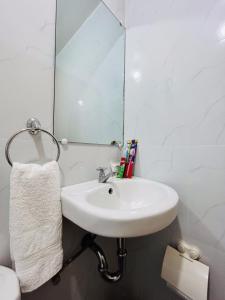 een badkamer met een wastafel en een spiegel bij Casa Concetta Apartelle with Pool in Manolo Fortich