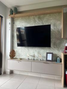 ein Wohnzimmer mit einem TV an der Wand in der Unterkunft Flat Eco Resort Carneiros in Rio Formoso