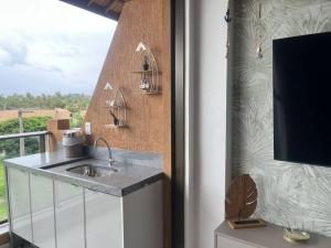 eine Küche mit einem Waschbecken neben einem Fenster in der Unterkunft Flat Eco Resort Carneiros in Rio Formoso