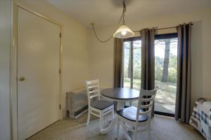 ein Esszimmer mit einem Tisch, Stühlen und einem Fenster in der Unterkunft Cedarbrook Hotel Room w/2 doubles 101 in Killington