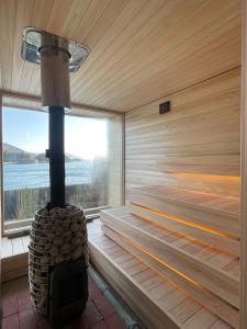 a wood stove in a sauna with a window at 離島-宿navelの学校-三原港から船で14分 in Mihara