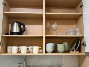a kitchen cabinet filled with cups and wine glasses at Hongdae Station loft apartment in Seoul