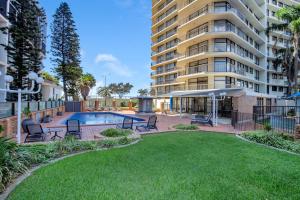 黄金海岸Beachfront & City View, Huge 2 Bedroom Apartment, Imperial Surf Resort的一座大型公寓楼,设有游泳池和庭院