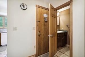 een badkamer met een houten deur en een wastafel bij Ski home on the trail from Showshed! Or take the free shuttle A2 in Killington