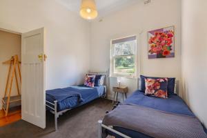 a bedroom with two beds and a window at Amongst the Vines Deluxe Retreat in Blewitts Springs