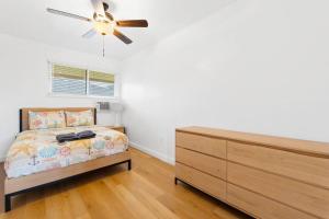 a bedroom with a bed and a ceiling fan at Shark's Cove Front, Sea View, Large 2BR, Full Kitchen, contact us for price drop in Haleiwa