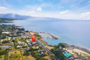 a red kite flying over a beach next to the water at Shark's Cove Front, Sea View, Large 2BR, Full Kitchen, contact us for price drop in Haleiwa
