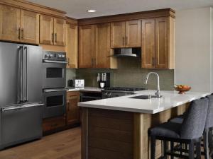 una cocina con electrodomésticos de acero inoxidable y armarios de madera en Hyatt Vacation Club at Northstar Lodge, en Truckee