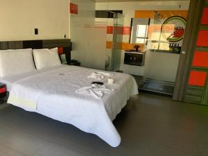 ein Schlafzimmer mit einem Bett, auf dem Handtücher liegen in der Unterkunft Hotel Planeta 3 in Bogotá