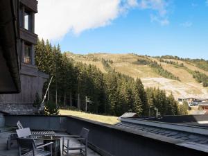 a balcony with a table and chairs and a mountain at Duplex 4 pers à Courchevel 1850 – Luxe et confort au pied des pistes - FR-1-631-175 in Courchevel