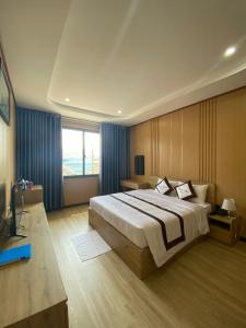 a bedroom with a large bed and a large window at Khách sạn - Nhà hàng Hoàng Phúc in Tuy Phong